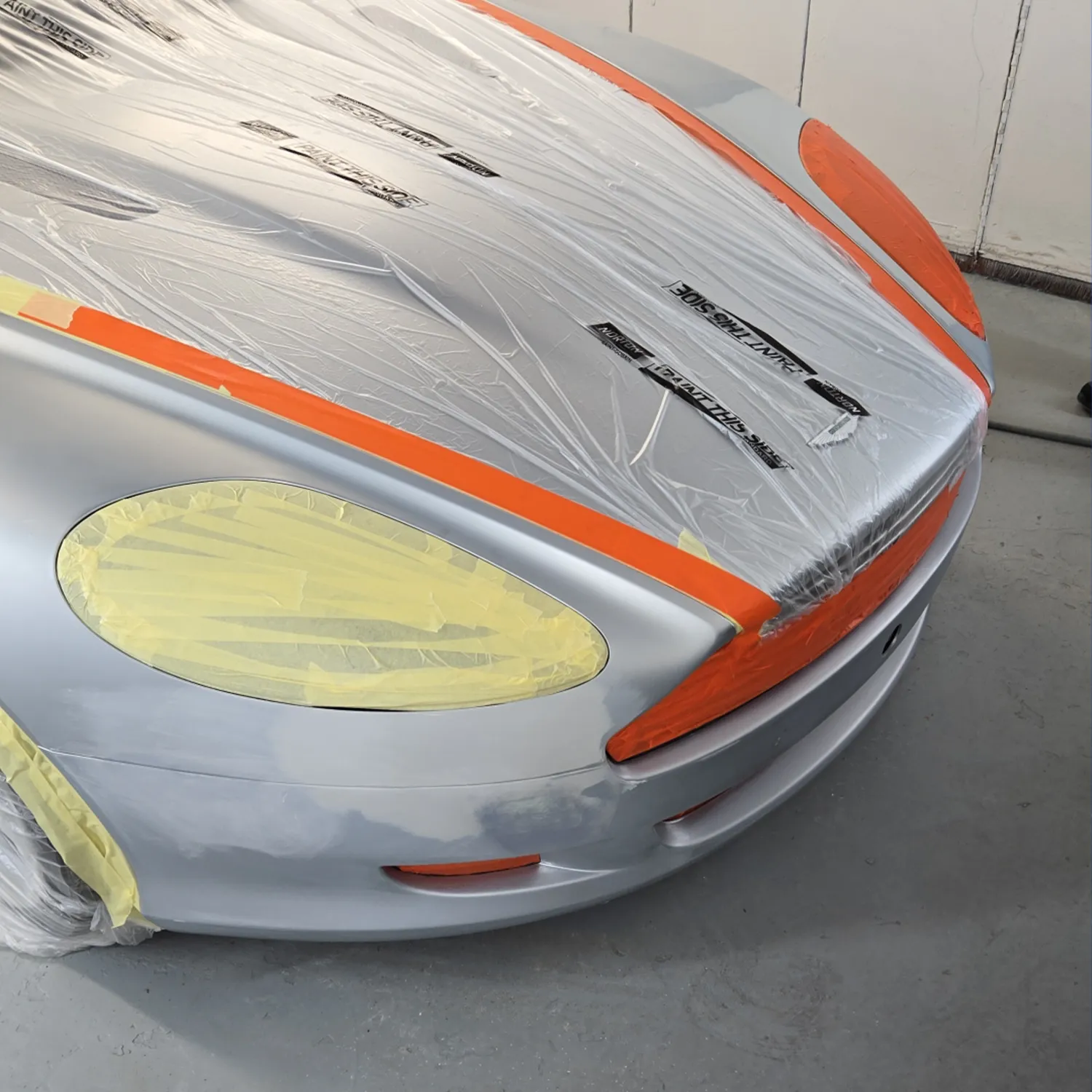 Front of a sports car masked and prepared with filler before painting